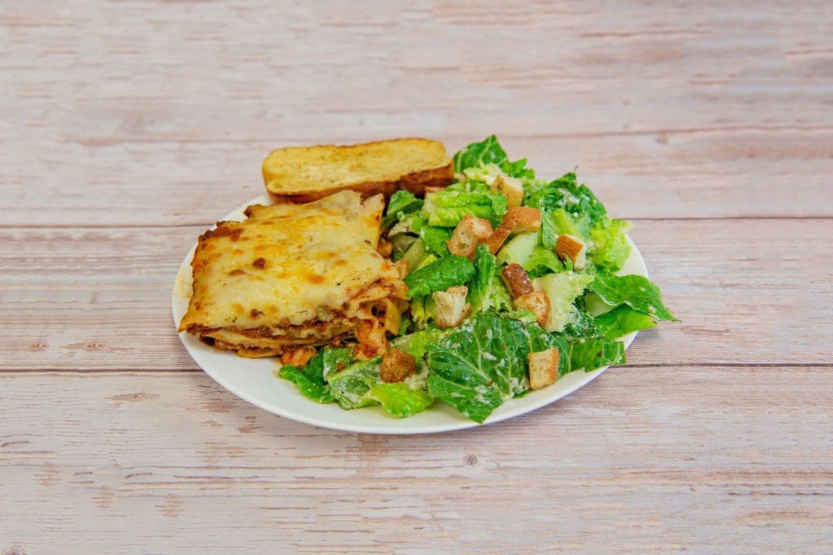 Lasagna with caesar salad and garlic bread